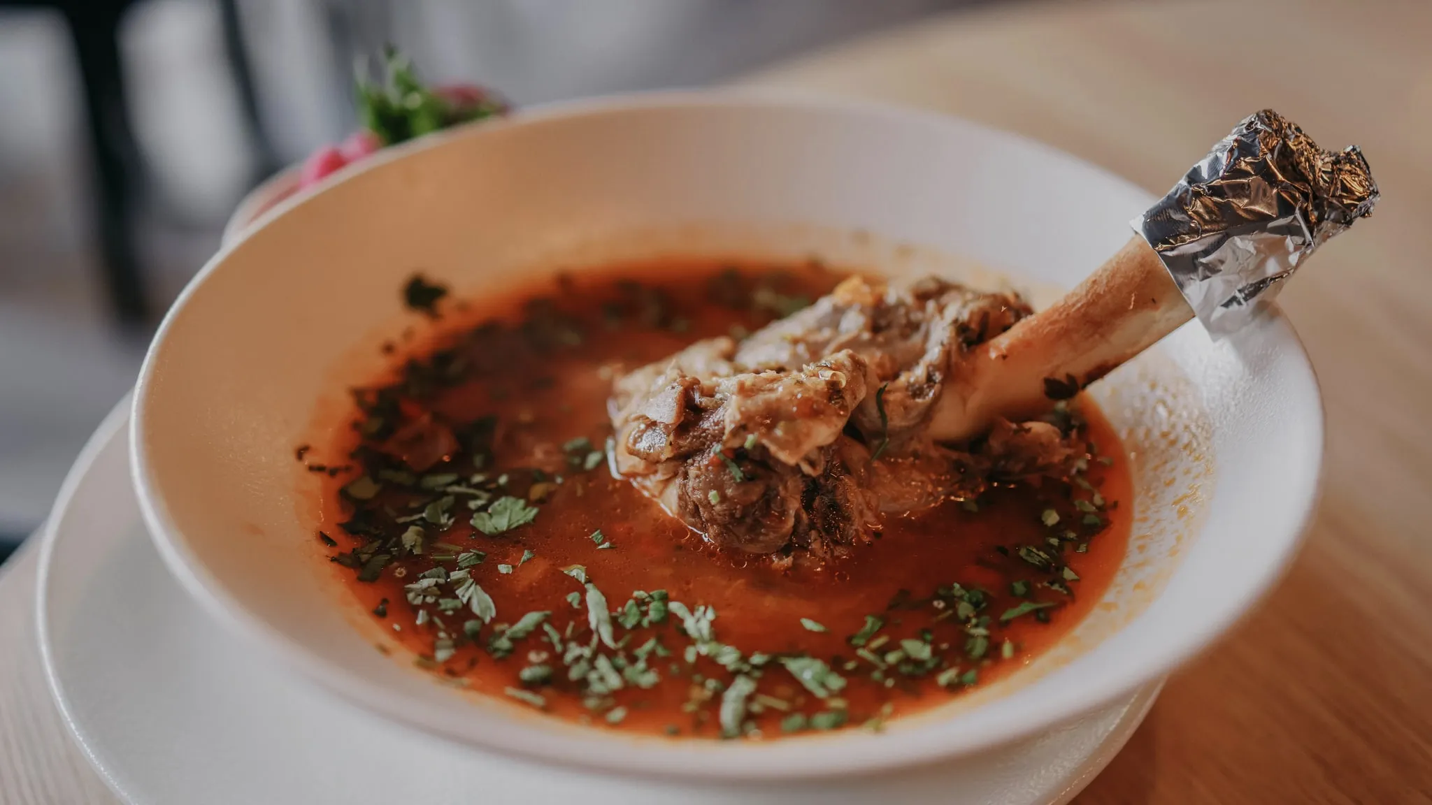 Bouillon van botten die zachtjes staat te trekken in een pan, close-up van het oppervlak.