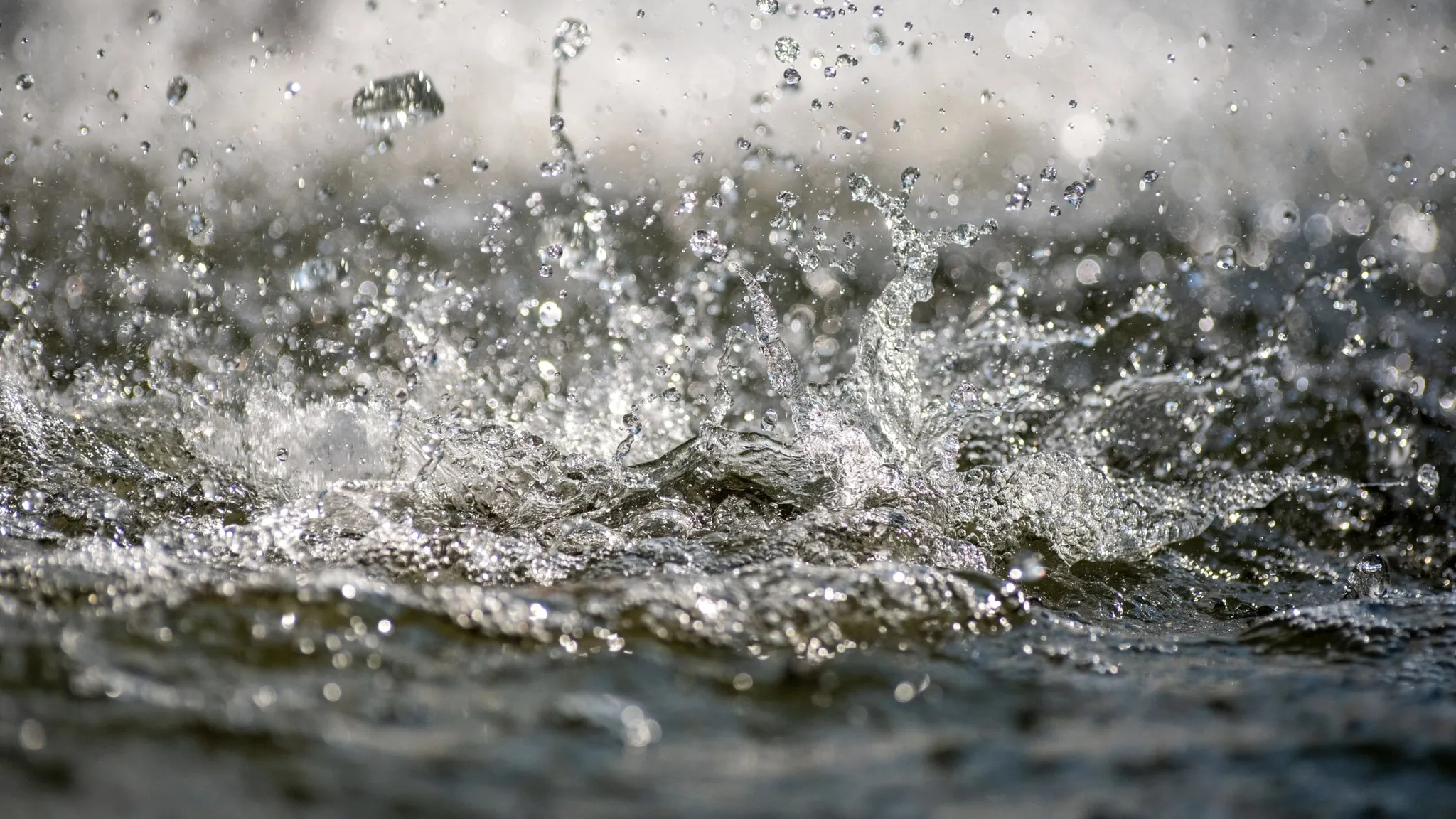Water dat opspat, in grijstinten en zacht licht gefotografeerd.