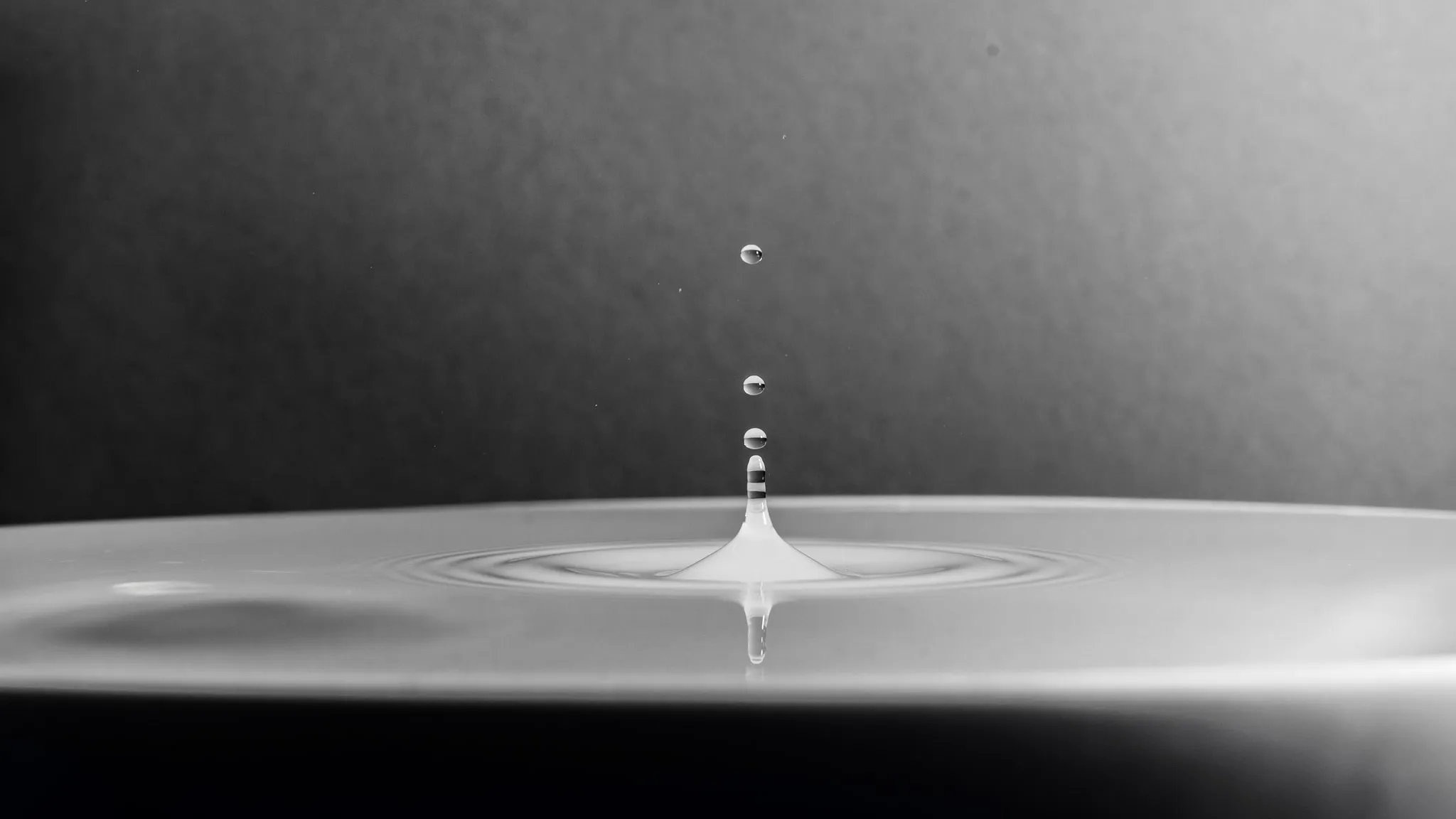 Een waterdruppel op een doorschijnend vlak, met het licht erachter.