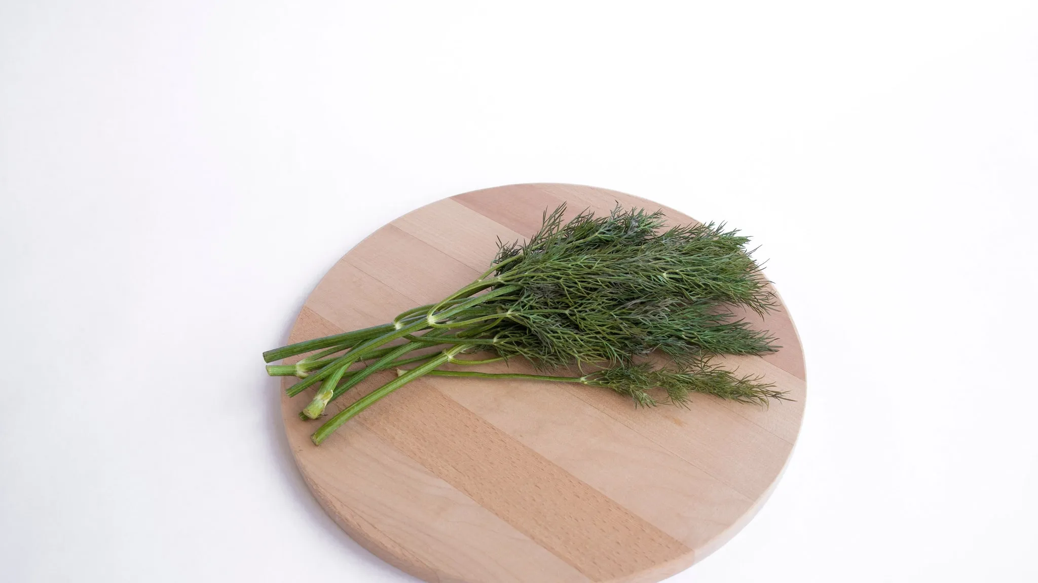 Een houten plank met gesneden rauwe groenten, van boven gezien bij daglicht.
