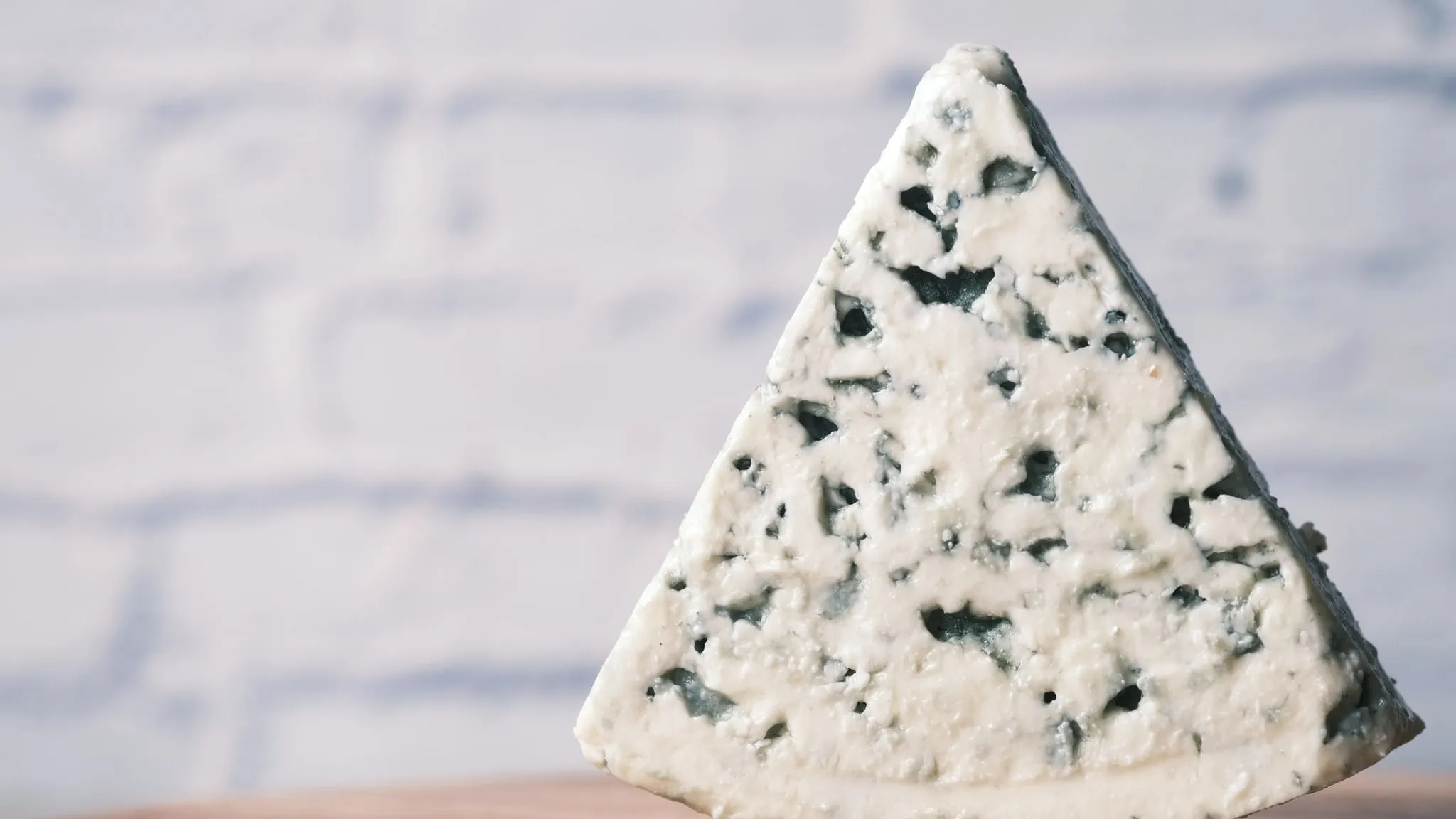 Close-up van een lepel die dikke yoghurt uit een keramieken potje tilt.